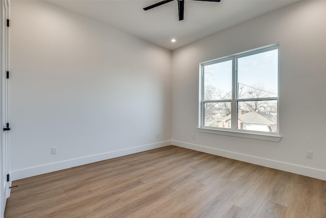 empty room featuring a healthy amount of sunlight, ceiling fan, and light hardwood / wood-style flooring