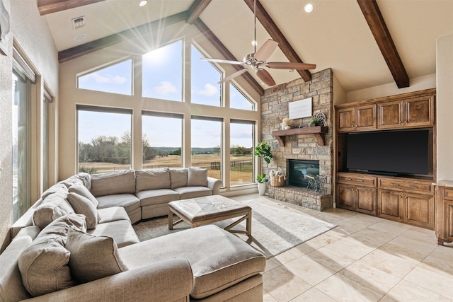 living room with light tile patterned floors, ceiling fan, high vaulted ceiling, a stone fireplace, and beamed ceiling