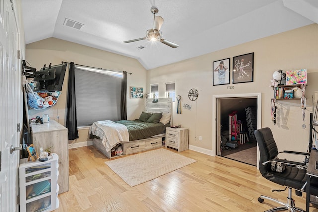 bedroom featuring lofted ceiling, light hardwood / wood-style floors, a closet, and ceiling fan