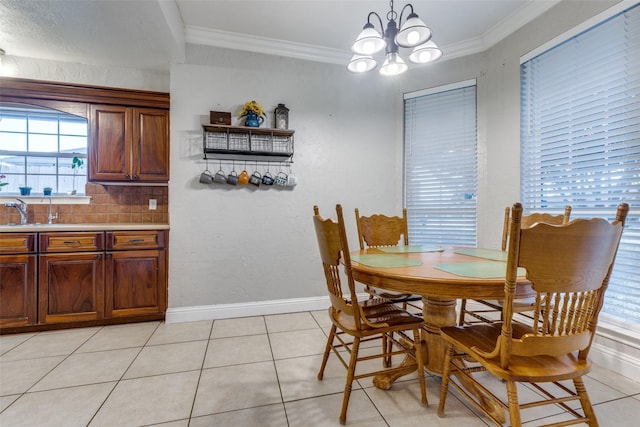 dining space with an inviting chandelier, light tile patterned floors, ornamental molding, and sink