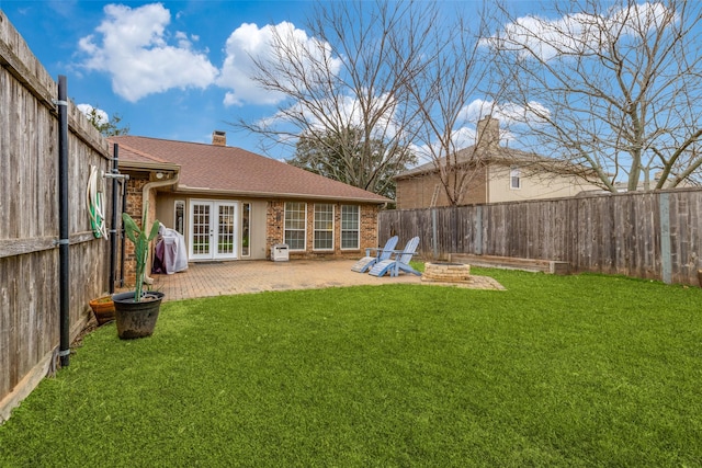 view of yard with french doors, a fire pit, and a patio area