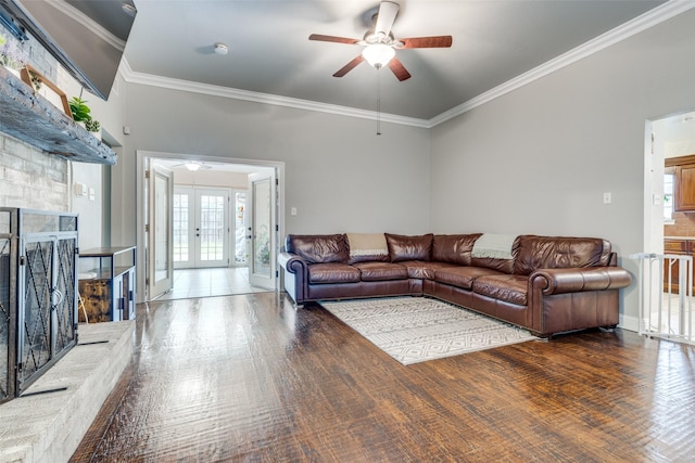 living room with dark hardwood / wood-style floors, a fireplace, ceiling fan, crown molding, and french doors