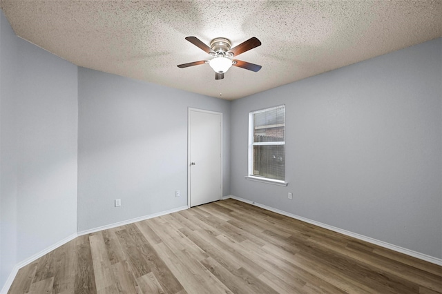 spare room featuring ceiling fan, light hardwood / wood-style floors, and a textured ceiling