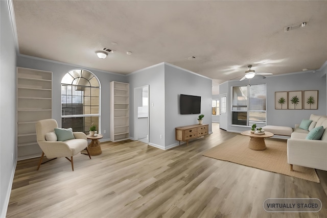 living room featuring crown molding, a fireplace, and light wood-type flooring