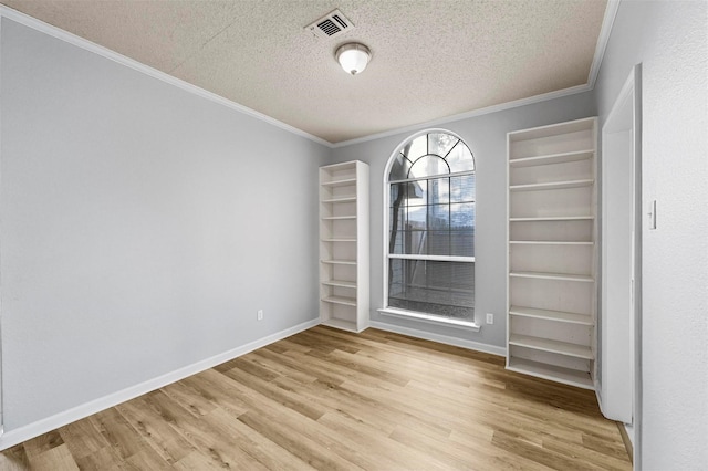 unfurnished room with ornamental molding, light hardwood / wood-style floors, and a textured ceiling