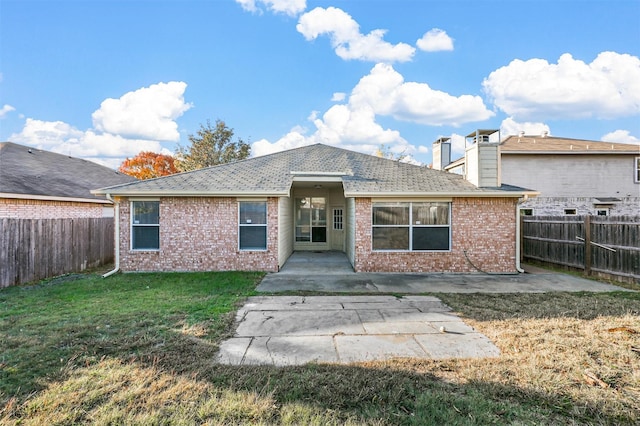 rear view of property featuring a lawn and a patio