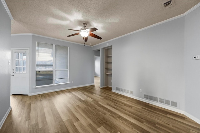 unfurnished room with hardwood / wood-style floors, ornamental molding, a textured ceiling, and ceiling fan