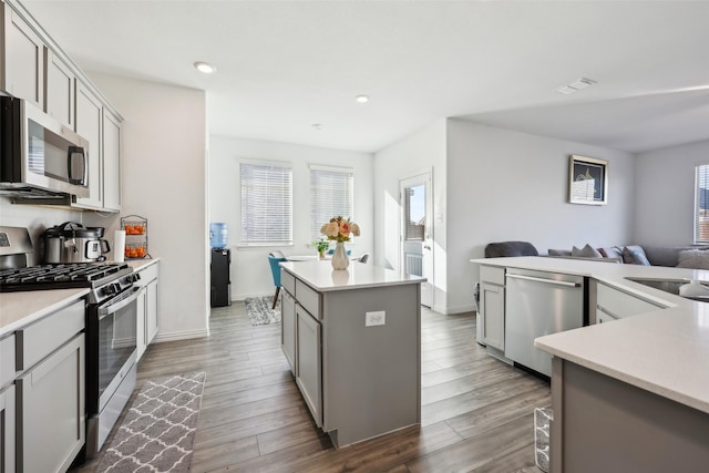 kitchen featuring gray cabinets, a kitchen island, dark hardwood / wood-style floors, sink, and stainless steel appliances