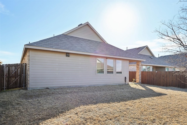 rear view of property featuring a lawn