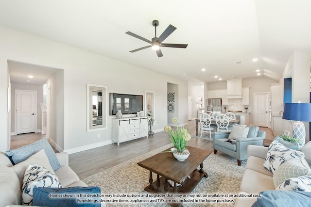 living room featuring vaulted ceiling, light wood-type flooring, and ceiling fan