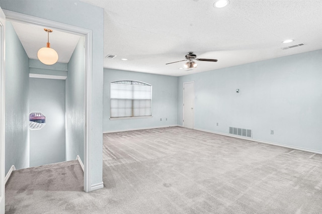 carpeted empty room with a textured ceiling and ceiling fan