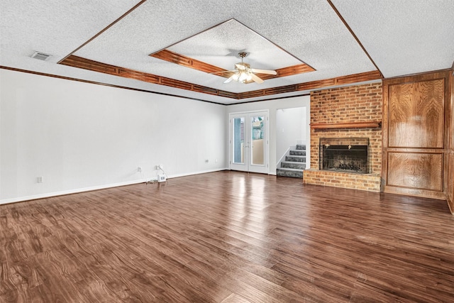 unfurnished living room with dark wood-type flooring, a fireplace, and a raised ceiling