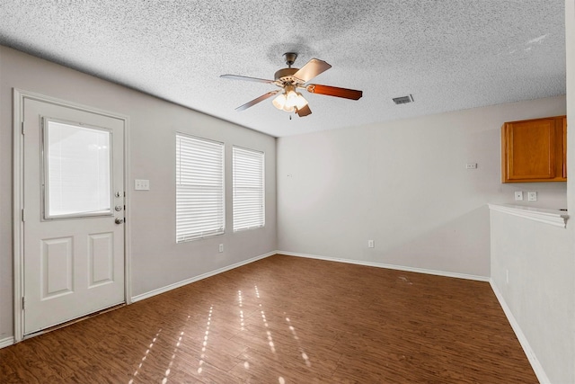 interior space with dark hardwood / wood-style flooring, a textured ceiling, and ceiling fan