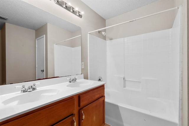 bathroom with vanity, shower / bathtub combination, and a textured ceiling