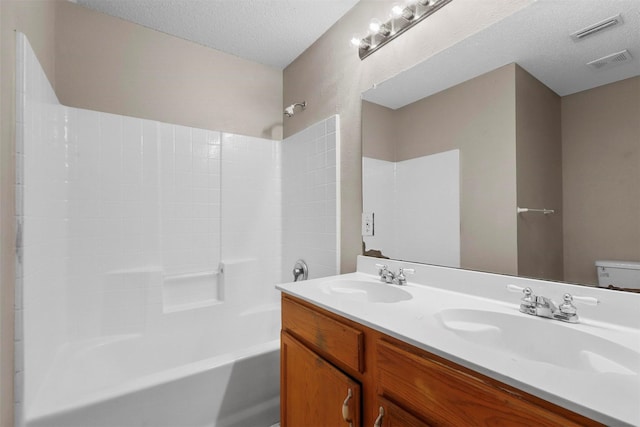 bathroom with vanity, bathing tub / shower combination, and a textured ceiling