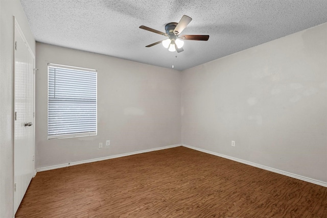 empty room with dark hardwood / wood-style flooring, ceiling fan, and a textured ceiling