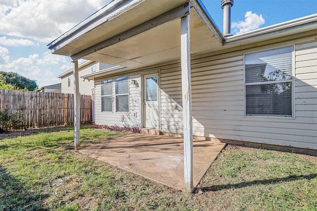 entrance to property featuring a yard and a patio area