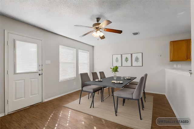 dining area with ceiling fan, hardwood / wood-style floors, and a textured ceiling