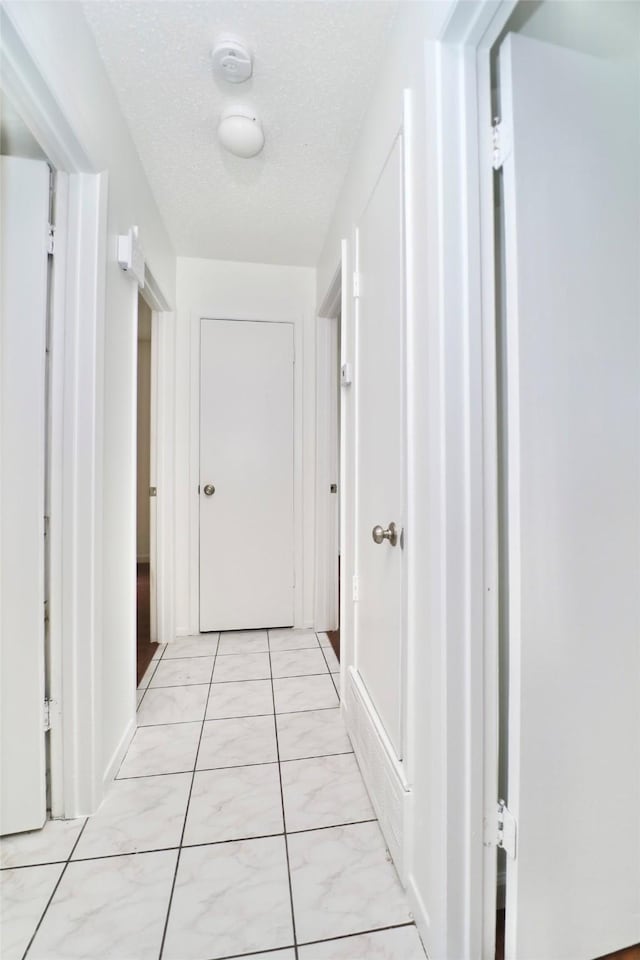 hallway with a textured ceiling