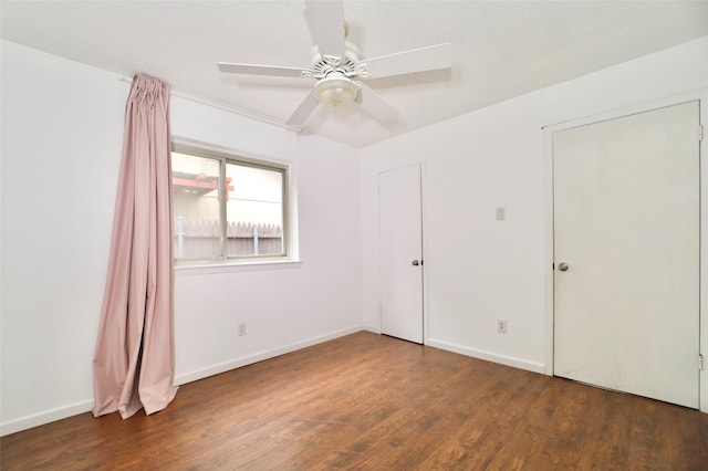 spare room featuring dark wood-type flooring and ceiling fan