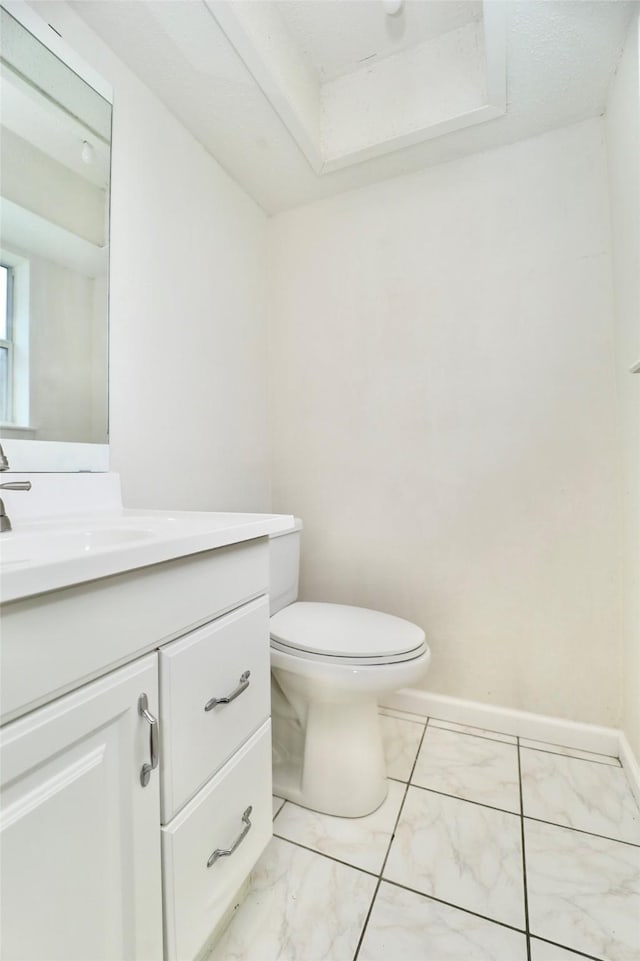 bathroom with vanity, toilet, and a tray ceiling