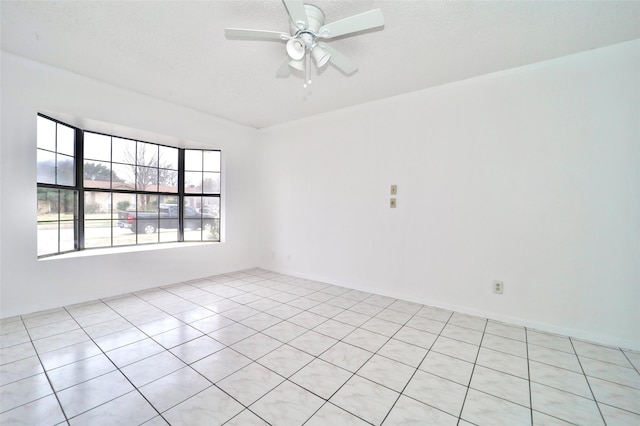 tiled empty room featuring a textured ceiling and ceiling fan