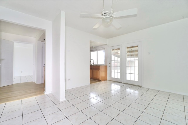 spare room featuring light tile patterned floors, sink, and ceiling fan