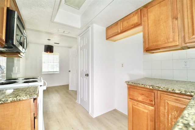 kitchen featuring tasteful backsplash, light hardwood / wood-style flooring, pendant lighting, light stone countertops, and white range with electric stovetop