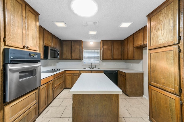 kitchen with sink, black appliances, a textured ceiling, and a kitchen island