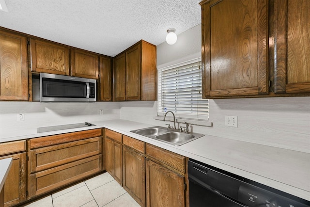 kitchen with sink, light tile patterned floors, a textured ceiling, and black appliances