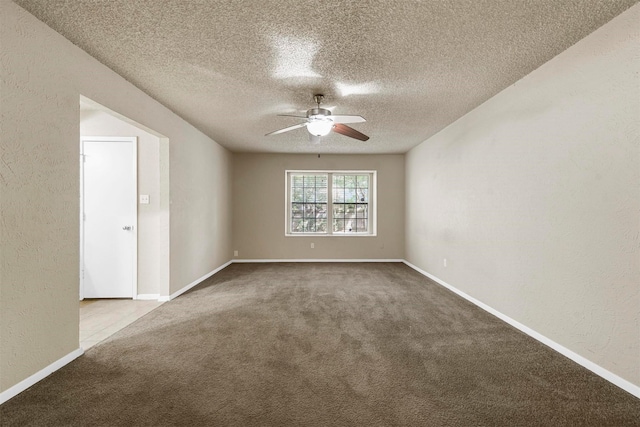 carpeted spare room featuring ceiling fan and a textured ceiling