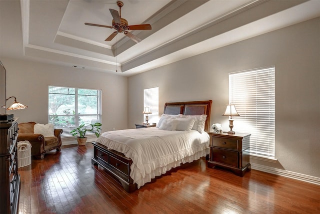 bedroom featuring crown molding, ceiling fan, dark hardwood / wood-style flooring, and a raised ceiling