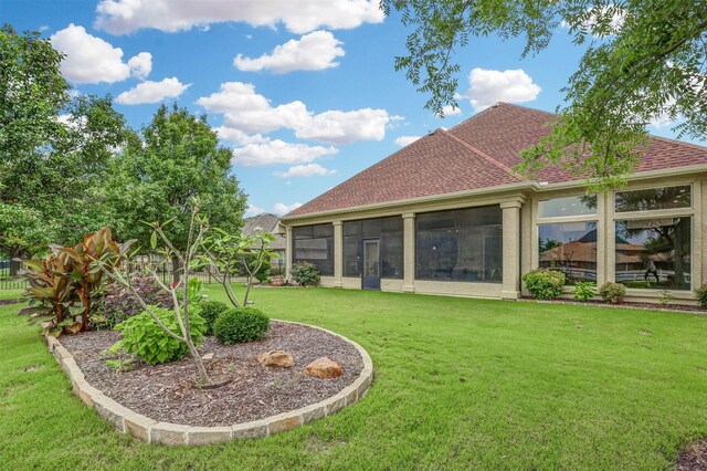 9801 Georgia Ave, Denton, TX 76207 - rear view of house featuring a lawn, roof with shingles, and a sunroom