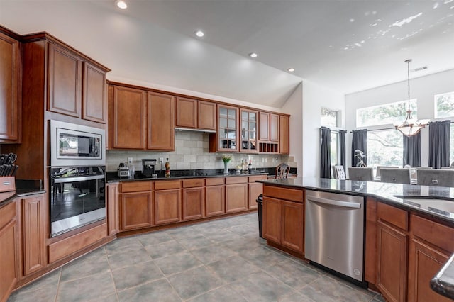9801 Georgia Ave, Denton, TX 76207 - kitchen featuring appliances with stainless steel finishes, lofted ceiling, a chandelier, backsplash, and brown cabinets