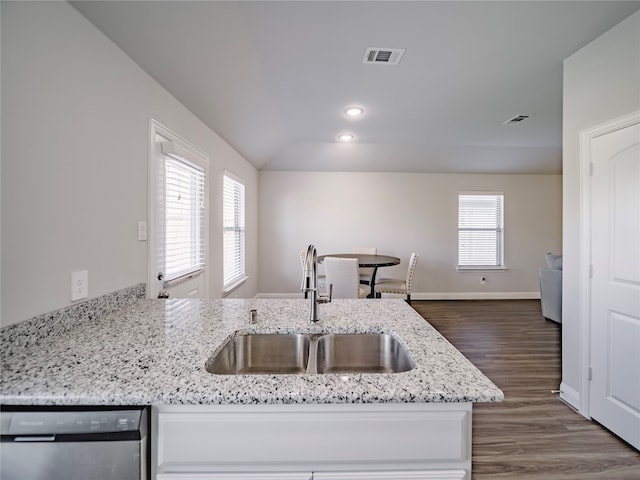 kitchen with sink, light stone counters, vaulted ceiling, stainless steel dishwasher, and a wealth of natural light