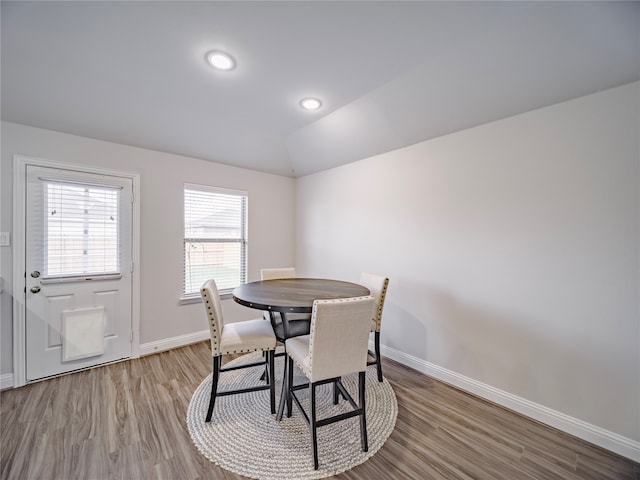 dining room with lofted ceiling and light wood-type flooring