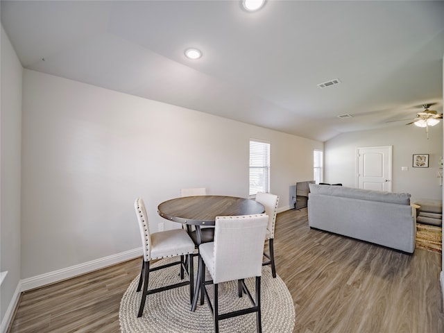 dining space featuring vaulted ceiling, ceiling fan, and hardwood / wood-style floors