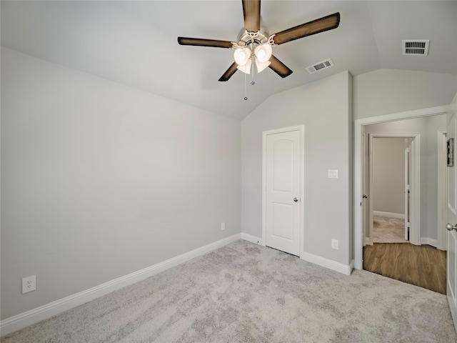 unfurnished bedroom featuring lofted ceiling, light colored carpet, and ceiling fan