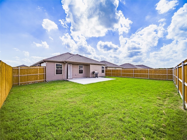 rear view of property featuring a yard and a patio