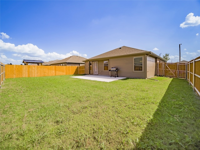 back of house featuring a patio area and a lawn