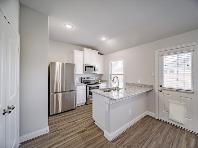 kitchen featuring a wealth of natural light, white cabinetry, sink, kitchen peninsula, and stainless steel appliances