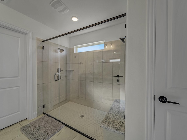 bathroom with walk in shower and tile patterned flooring