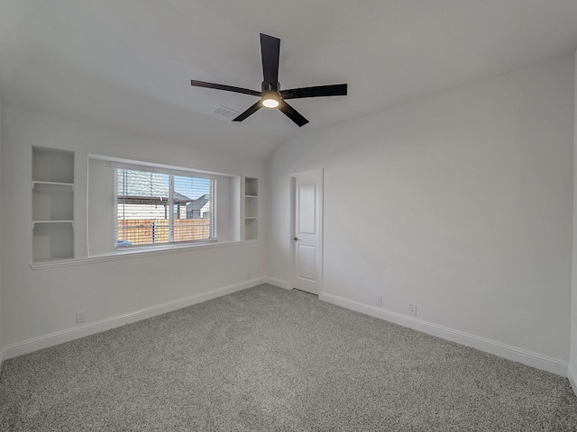 spare room with carpet flooring, ceiling fan, and built in shelves