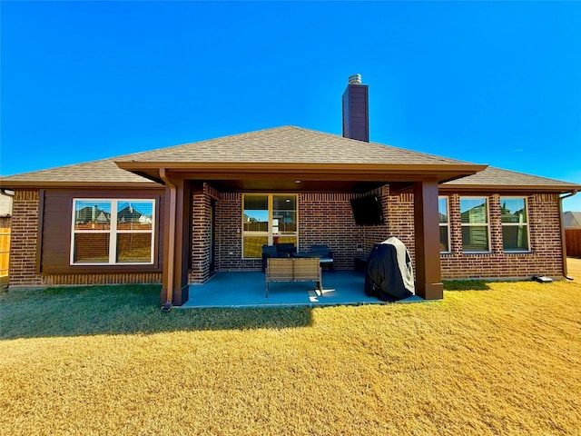 back of property featuring a patio and a lawn