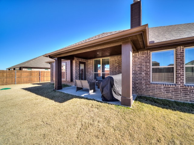 rear view of property featuring a yard and a patio