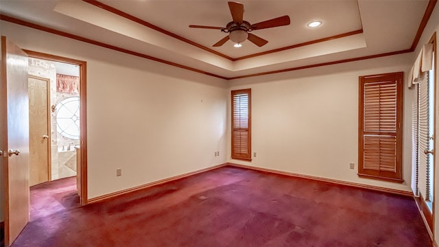 empty room featuring crown molding, a tray ceiling, and carpet floors