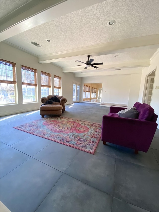 living room with ceiling fan, beam ceiling, and a textured ceiling