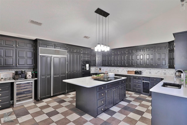 kitchen with pendant lighting, sink, beverage cooler, and a kitchen island