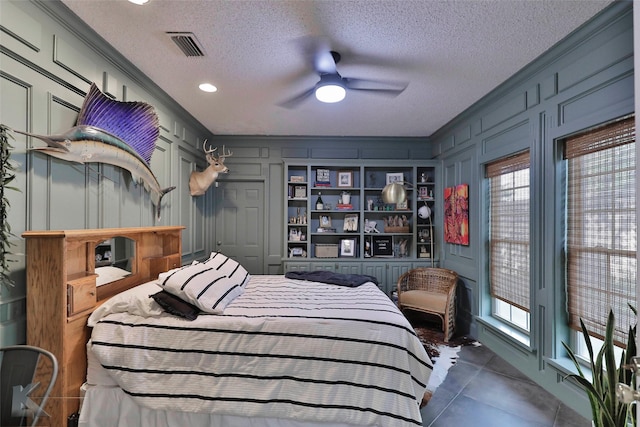 bedroom with ceiling fan, ornamental molding, and a textured ceiling