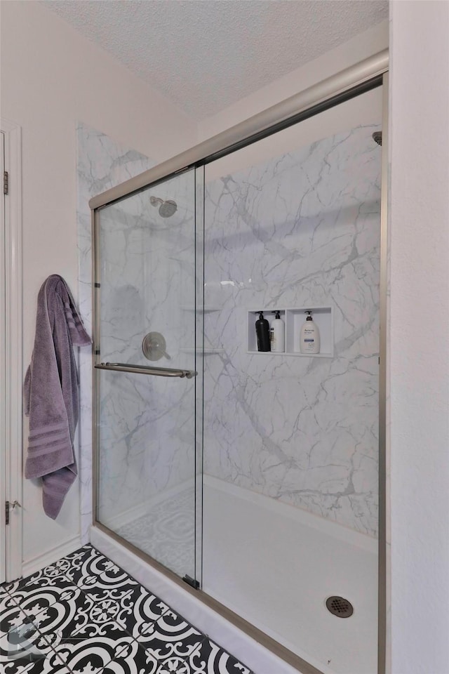 bathroom featuring an enclosed shower and a textured ceiling